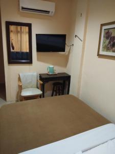 a bedroom with a bed and a desk and a tv at KL CITY LODGE in Kuala Lumpur +12 photos