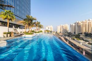 a large swimming pool in a city with tall buildings at The Palm Tower in Dubai
