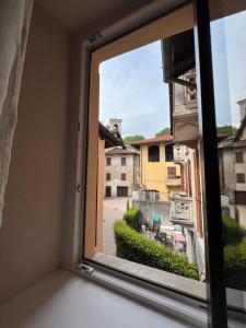 a window with a view of a city street at OSTERIA al CANTONACCIO ROOMS in Brusimpiano
