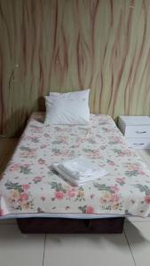 ein Bett mit einer Blumendecke und einem Kissen in der Unterkunft ÇARŞI HOTEL&CAFE in Trabzon