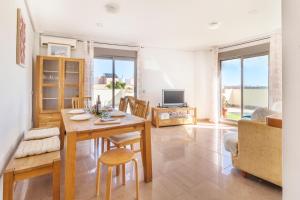 uma sala de estar com uma mesa e cadeiras e uma televisão em Penthouse in the Sun em El Alquián