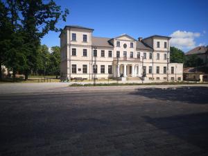 a large white building with a lot of windows at Aušros Alėjos Apartamentai in Šiauliai