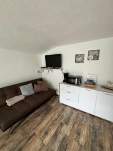 een woonkamer met een bank en een flatscreen-tv bij Ferienwohnung Raich in Wenns
