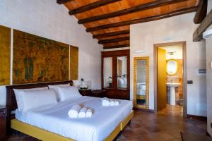 1 dormitorio con 1 cama grande con almohadas blancas en Villa Vittoria Hotel, en Alcamo