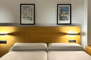 a bedroom with a bed with three pictures on the wall at Hotel Don Ignacio in San José