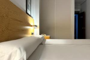 a bedroom with a large white bed and a window at Hotel Don Ignacio in San José