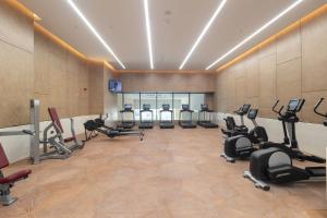 a gym with a row of treadmills and exercise bikes at The Palm Tower in Dubai