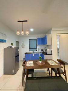 a kitchen with a wooden table and a kitchen with blue cabinets at Allure - Casa Kayangan Meru Ipoh by GOSWELL in Ipoh