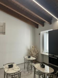 a room with tables and chairs and a tv at Il Vico Del Drago in LʼAquila