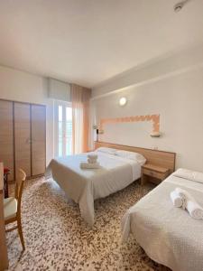 una camera d'albergo con due letti e una finestra di Hotel Ravello Adults Only a Rimini