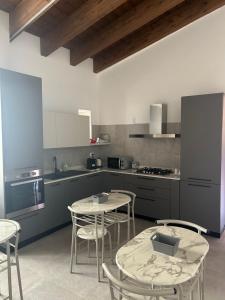 a kitchen with a table and chairs and a counter at Il Vico Del Drago in LʼAquila