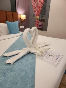 a pair of swans made out of towels on a bed at Solitude, The Boutique Hotel in Haldwāni