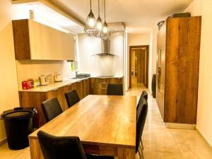 uma cozinha com uma mesa de jantar em madeira e cadeiras em Sliema Jacuzzi Flat em Sliema
