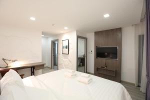 曼谷的住宿－U42 Hotel Bangkok，卧室配有白色的床和电视。