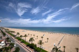 a beach with palm trees and people on it at Villa Xauxa - Vida mediterránea in Gandía