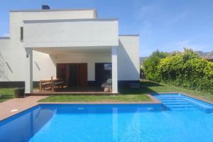 a villa with a swimming pool in front of a house at Villa Xauxa - Vida mediterránea in Gandía