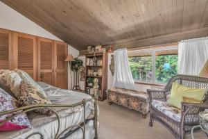 ein Schlafzimmer mit einem Bett, einem Stuhl und einem Fenster in der Unterkunft Driftwood Beach Guest House in Seal Rock