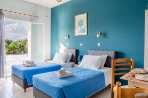 a room with two beds and a blue wall at Anastasia Studios Katelios in Katelios