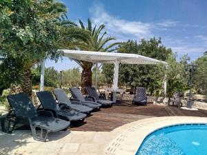 - un groupe de chaises assises à côté de la piscine dans l'établissement dependance in villa con piscina, à Raguse
