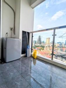 a kitchen with a view of a city from a window at Claudio Homestay - 11th Floor - City Views - 55 UHD TV in Phnom Penh