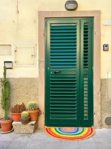 una puerta verde al lado de un edificio con macetas en La Petite - Certaldo, en Certaldo