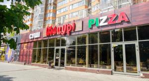 a pizza store with a sign on the front of it at VIP апартаменти ЦЕНТР in Rivne