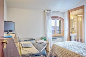 a bedroom with a bed and a desk with a laptop at Affittacamere nel cuore della Toscana a 20 minuti da Firenze in Empoli +32 photos