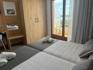 1 dormitorio con 1 cama grande y balcón en Hostal Santa Clara, en L'Estartit