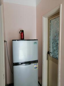 um frigorífico num quarto com um recipiente vermelho por cima em شقة الولاء Loyalty apartment em Dumyat al Jadidah
