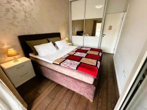 a small bedroom with a bed and a mirror at Stan na dan Podgorica in Podgorica