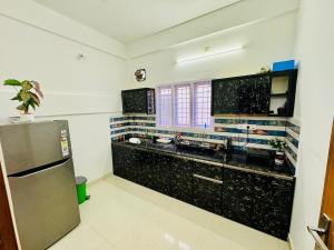 科欽的住宿－Spacious 2BHK Near Airport，厨房配有黑色柜台和不锈钢冰箱。