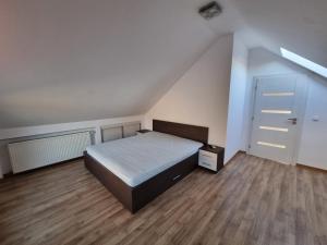 una camera da letto con un letto e un pavimento in legno di Casa Toni a Bistriţa