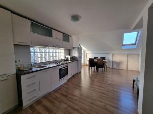 una grande cucina con armadi bianchi e una sala da pranzo di Casa Toni a Bistriţa