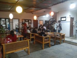un gruppo di persone seduti ai tavoli in un ristorante di Hotel Lake n Yeti a Pokhara