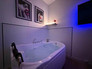 a white bath tub in a bathroom with purple lights at Orléans Centre - LOVE ROOM - Good Vibes Only in Orléans