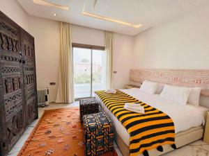 a bedroom with a large bed and a large window at Villa Africa in Essaouira