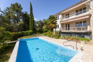 a swimming pool in front of a building at Vida's Place in Malinska