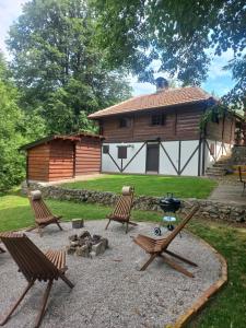 - une terrasse avec 2 chaises et un grill en face d'une cabine dans l'établissement Vikendica Bajka, à Despotovac