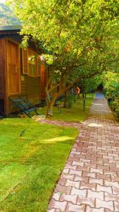 a brick path in front of a house with a tree at Olympos Varuna Bungalows in Olympos