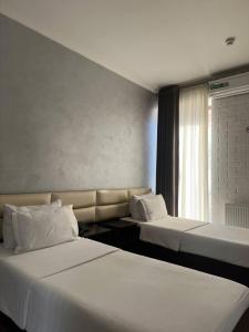 een hotelkamer met 2 bedden en een raam bij Orion Hotel Tashkent in Tasjkent