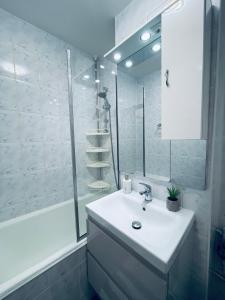 a white bathroom with a sink and a shower at La Burini in Vaslui