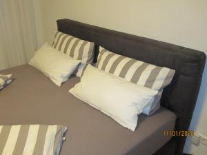 a bed with four white pillows on it at Ferien- bzw. Zeitwohnen Burglengenfeld » Apartment 2 in Burglengenfeld