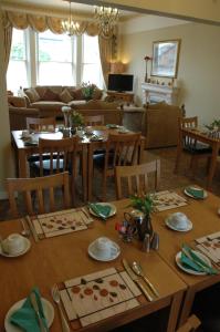 a dining room with a table and a living room at The Bebington in Bebington