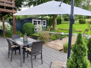 a patio with a table and chairs and an umbrella at Schöne Wohnung im Landhausstil nahe Olpe Biggesee in Olpe