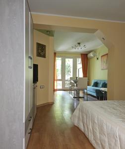 a bedroom with a bed and a living room at Cozy Place - в центъра, само на 5 минути пеша от плажа in Burgas