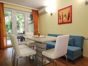 a living room with a blue couch and a table and chairs at Cozy Place - в центъра, само на 5 минути пеша от плажа in Burgas