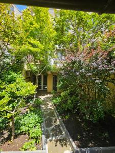 a garden in front of a house with trees at Cozy Place - в центъра, само на 5 минути пеша от плажа in Burgas