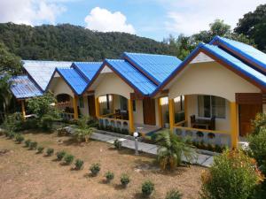 une rangée de maisons avec des panneaux solaires sur leur toit dans l'établissement Lanta Together, à Ko Lanta