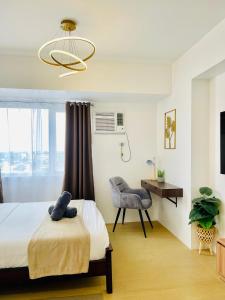 a bedroom with a bed and a chair and a window at Spacious Stylish Studio Unit at Avida Aspira Tower 1 in Cagayan de Oro +29 photos