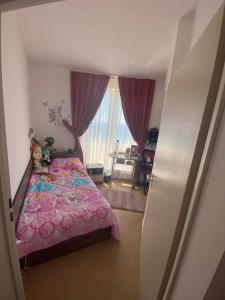 a bedroom with a bed with a pink bedspread at Aparthotel Costa Calma in Aheloy